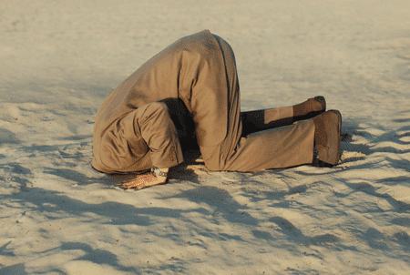 Man sticking head in the sand